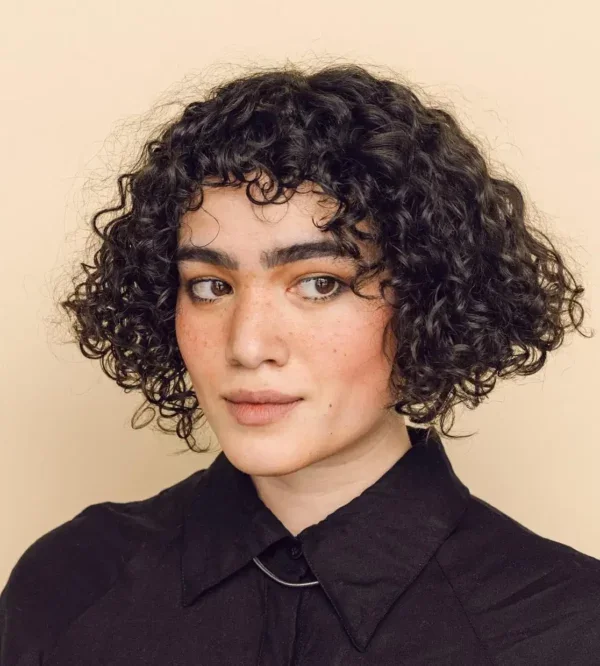 Woman with micro bangs on curly hair