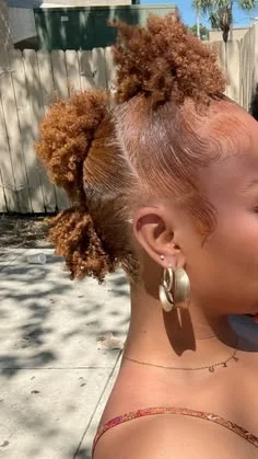 Woman with a small curly puff bun