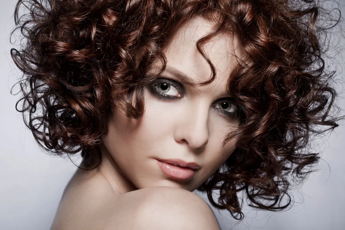 Woman with a short defined ringlet curly cut
