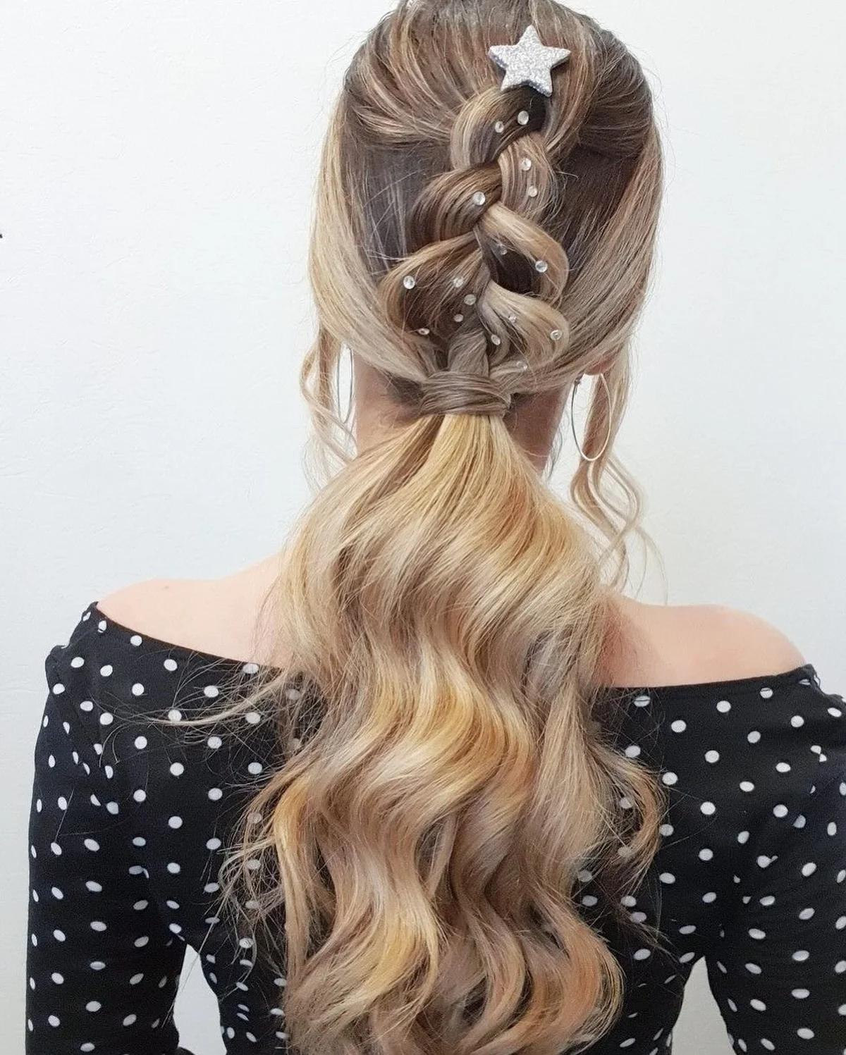 Blonde wavy ponytail with a twisted crown braid decorated with rhinestones