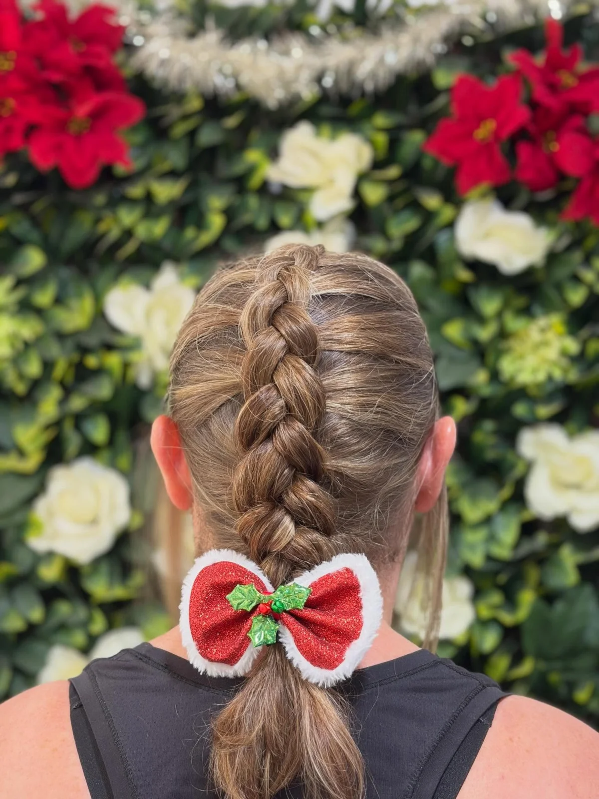 Thick symmetrical brown braid photographed in a floral studio