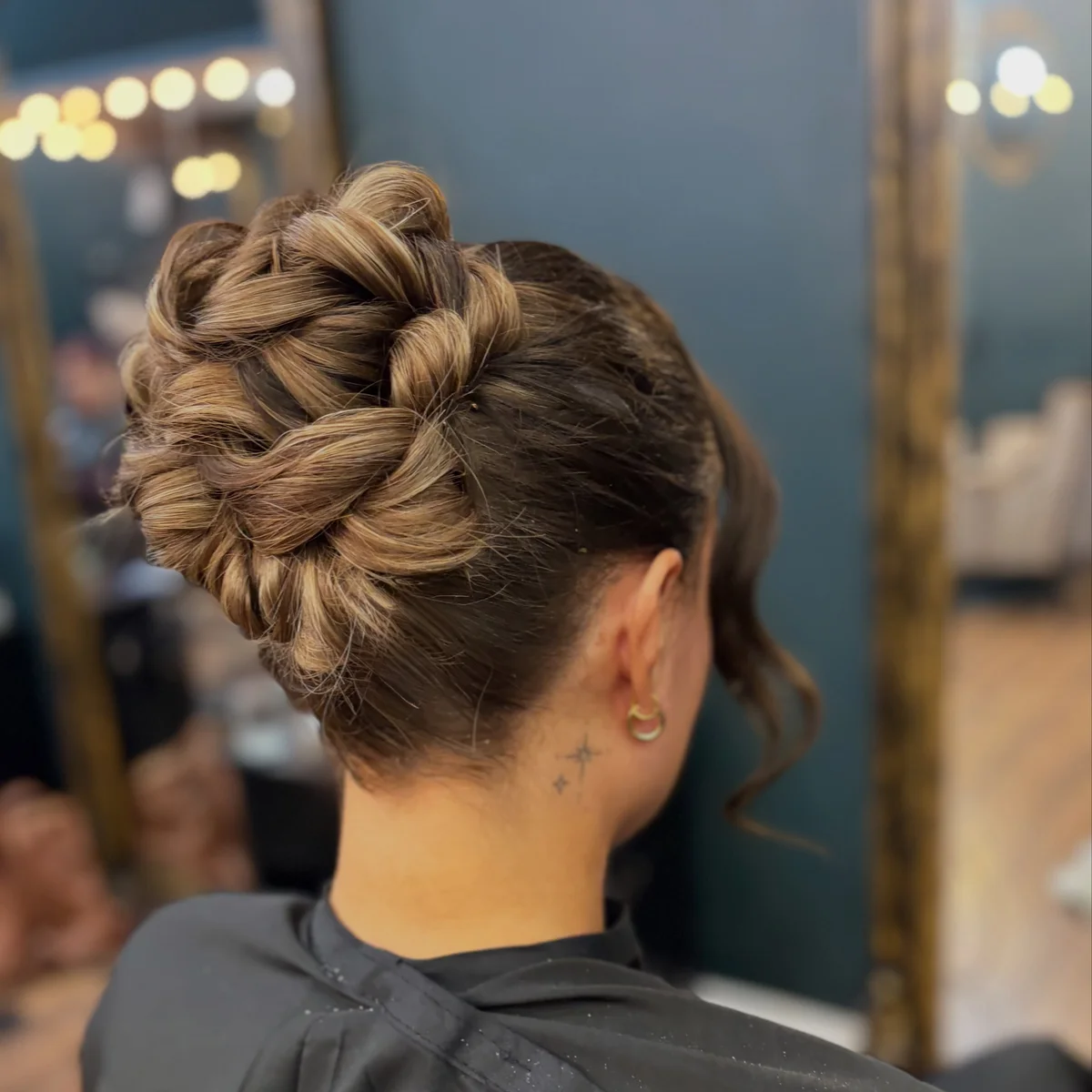 Intricate braided updo in brown hair with blonde highlights