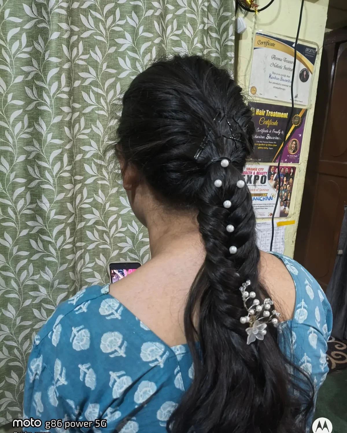 Dark side fishtail braid secured with pearl hairpins and a floral accessory
