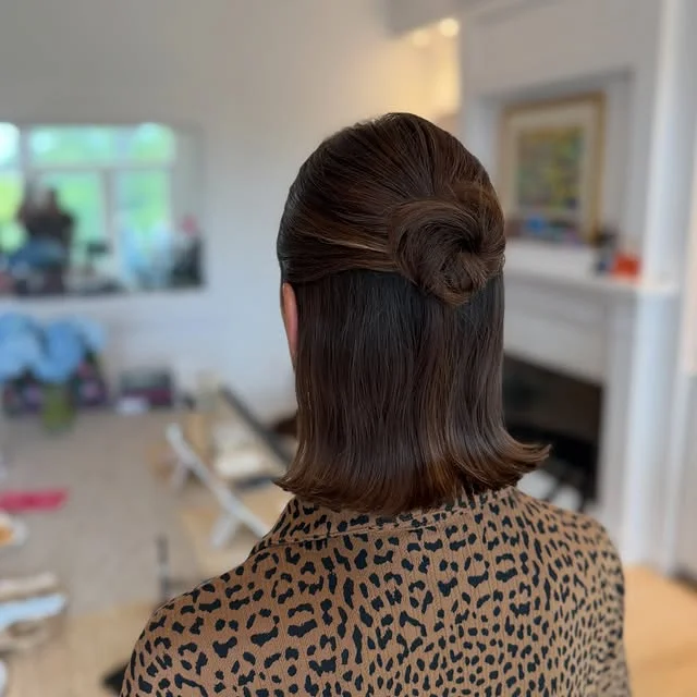 Rear view of a brown bob styled with the top half twisted into a small knot at the crown.