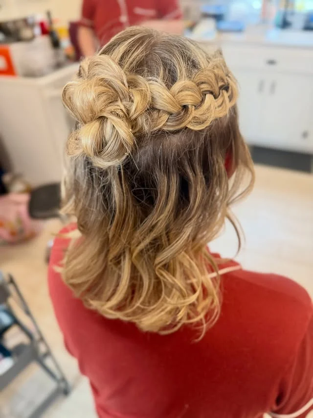 Rear view of a wavy bob with a thick looped braid woven across the crown of the head.