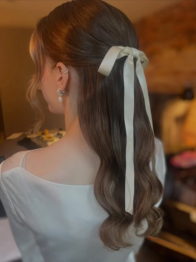 Sleek half-up style with a smooth top section and soft waves below
