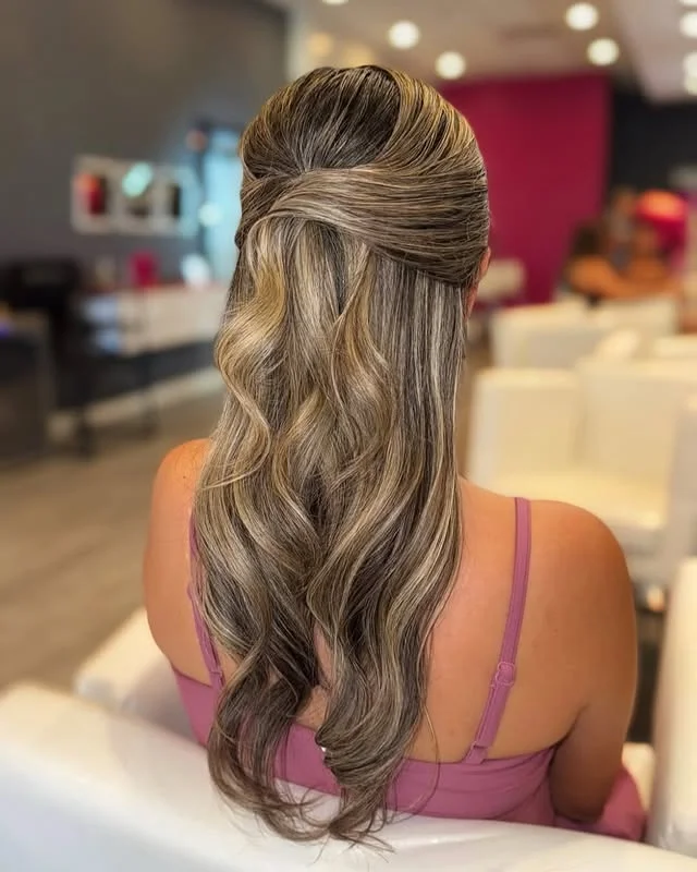 Half-up hairstyle with smooth wrapped sections at the crown and long wavy hair below
