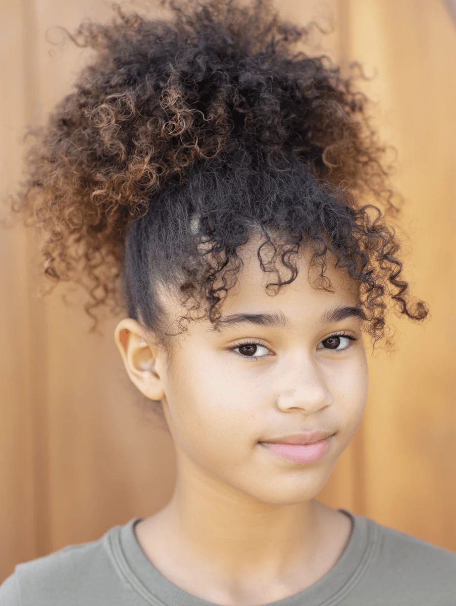Girl with a high curly pineapple puff