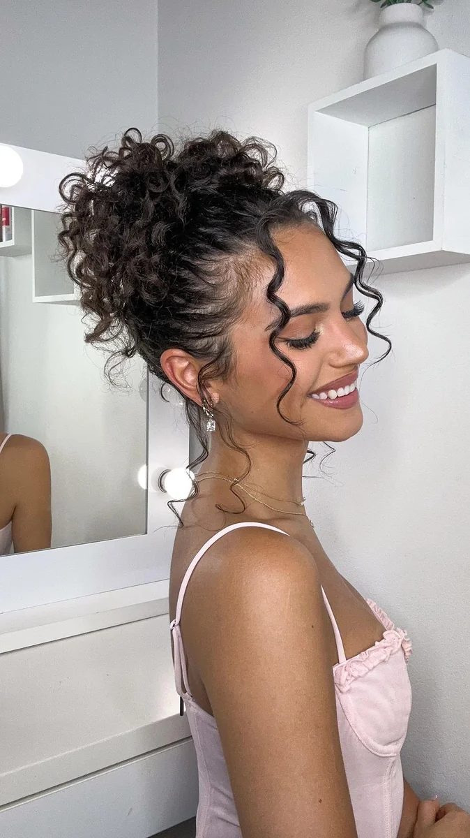 Woman with a messy curly top bun