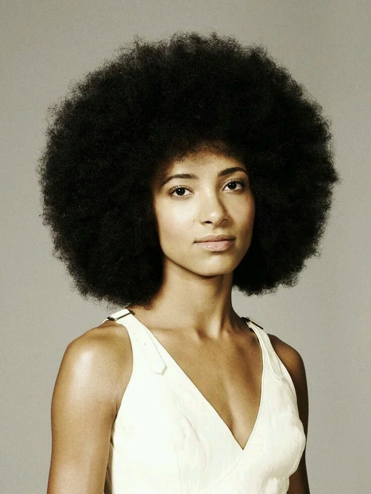 Woman with a voluminous afro and fringe