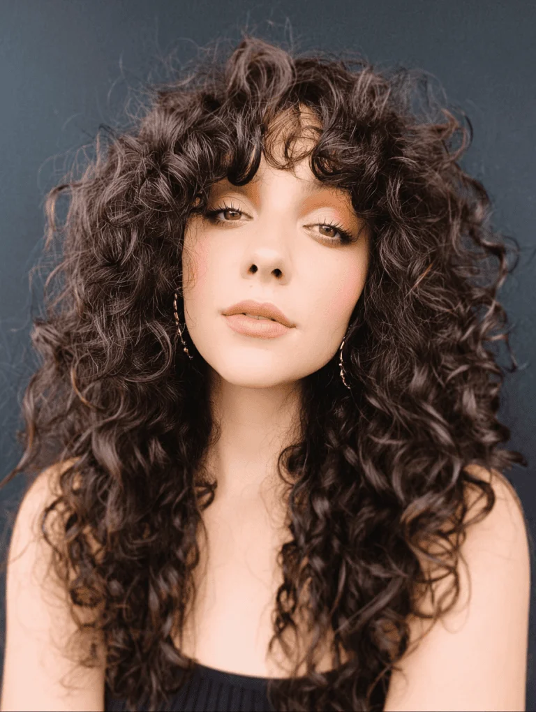 Woman with soft face framing curly layers