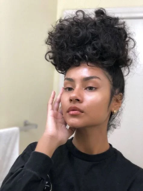 Woman with a polished high curly puff