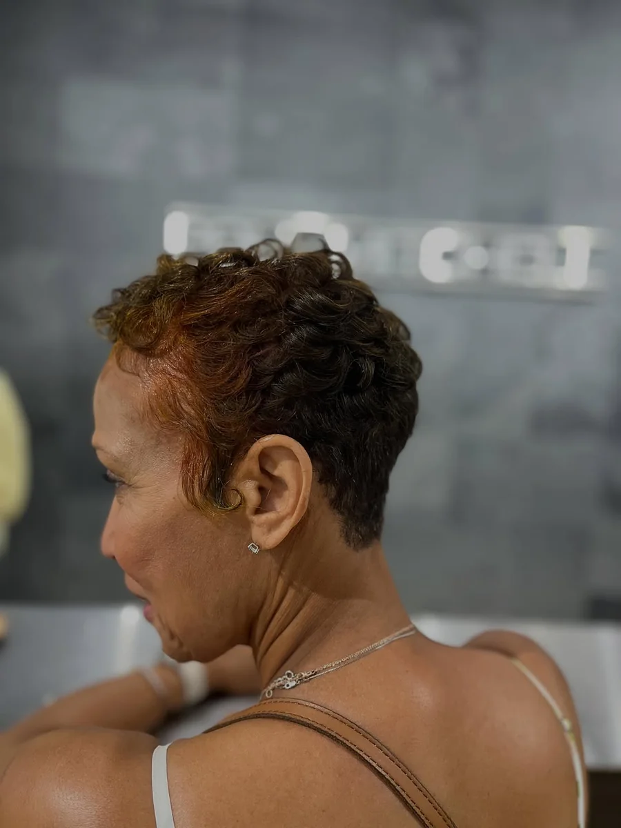 Woman with short tapered spiral curls pixie