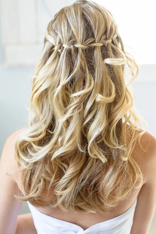 Woman with a waterfall twist in curly prom hair