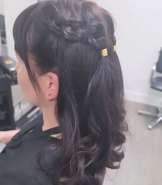 Side view of a Dutch braid across the crown finished with gold hair cuffs.
