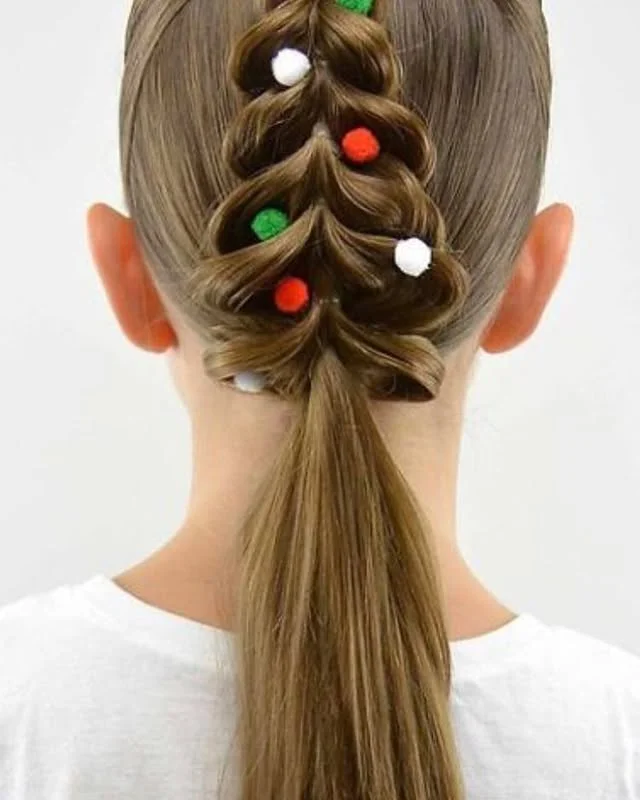 Child's hair styled into a Christmas tree shape with red, green and white pom-poms.