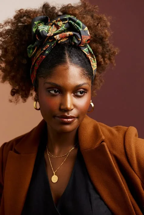 Woman styling curly hair with a silk scarf