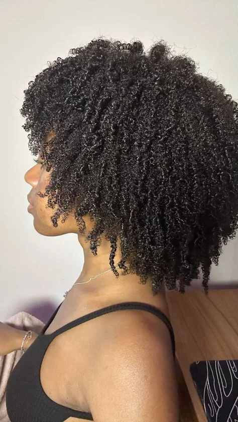 Woman with glossy defined coils at shoulder length