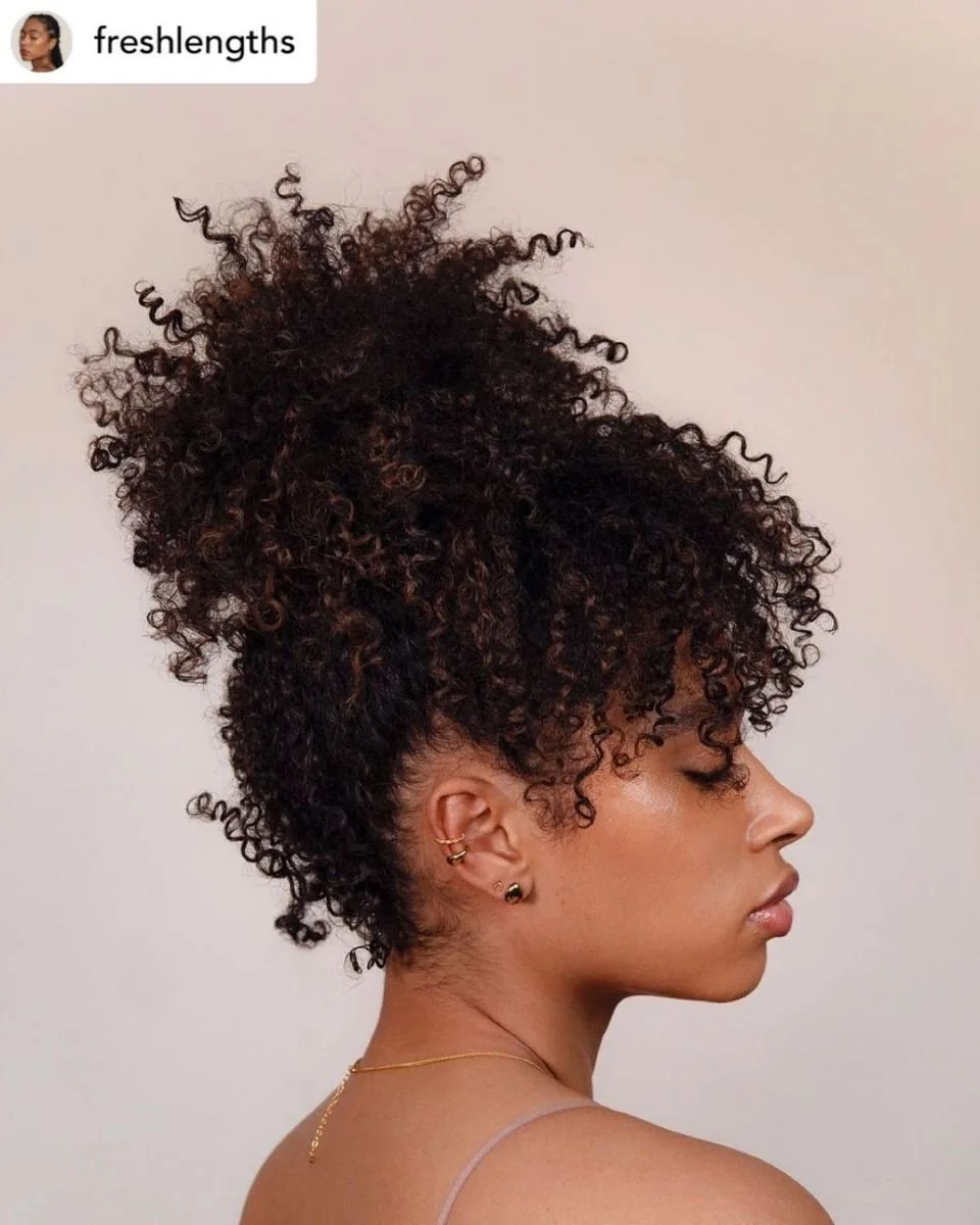 Woman with a high pineapple topknot of curly hair
