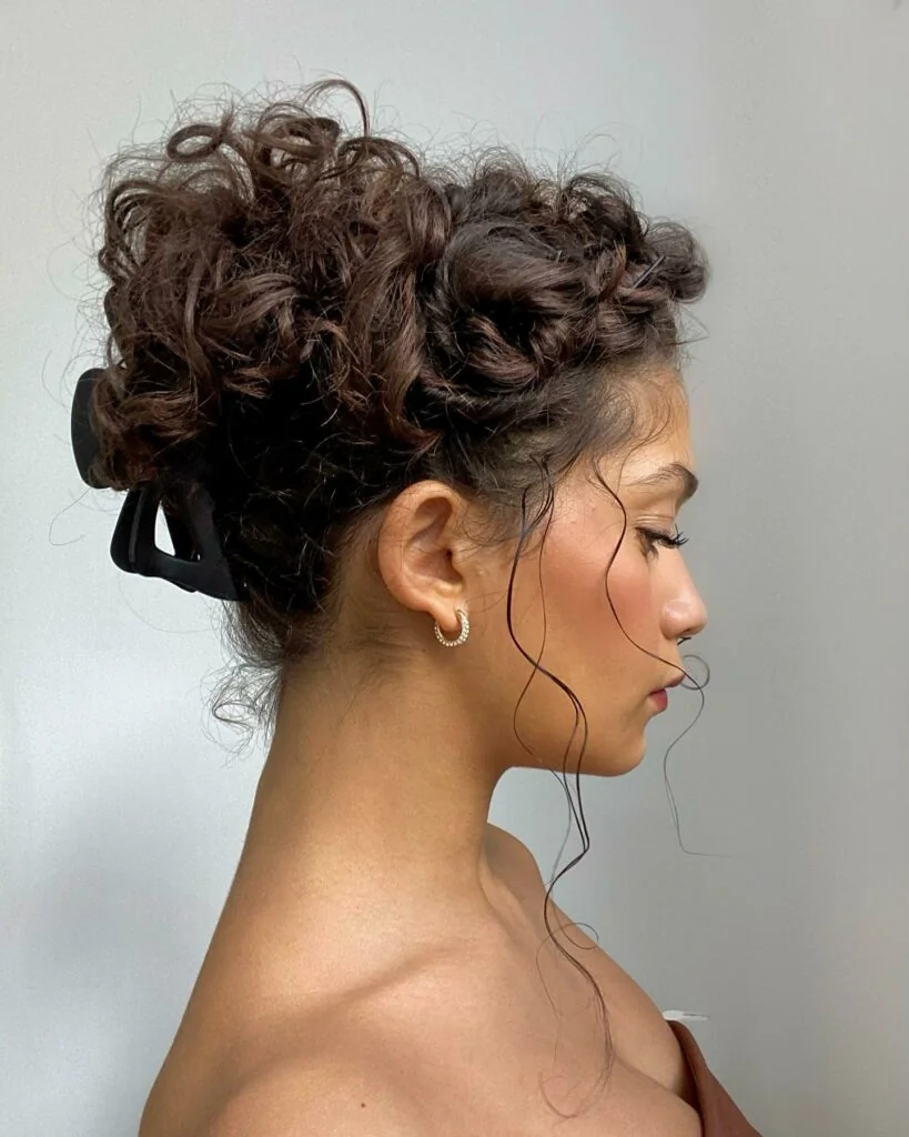 Woman with curly hair pinned back at the front