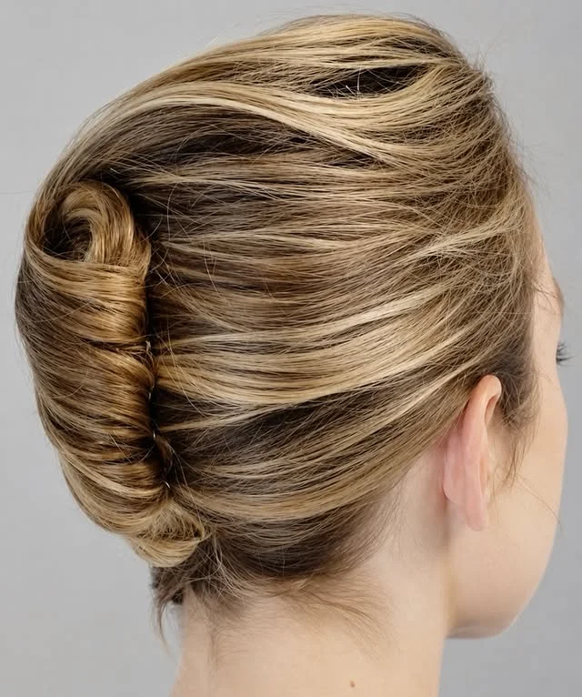 Classic French roll updo in blonde hair with darker lowlights.