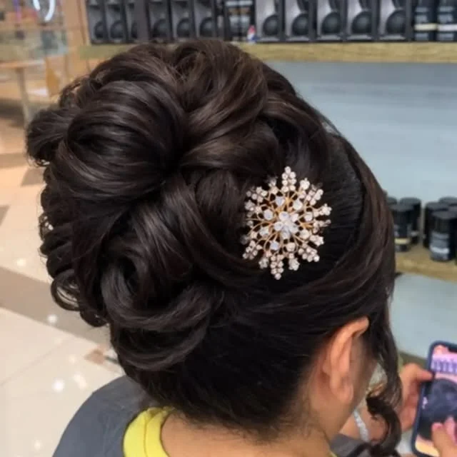 Formal updo with twisted sections, curls and a crystal snowflake hair pin.